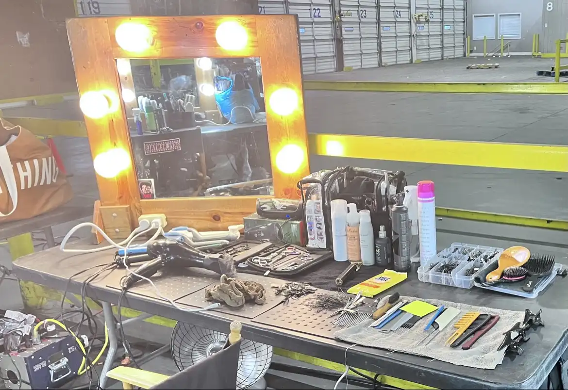 The agency's station set up on a production stage — lit vanity mirror, tools and kit laid out ready for work
